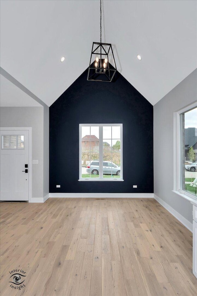16451 Kayla Dr, Lemont, IL 60439 - unfurnished living room featuring light wood-type flooring, lofted ceiling, a chandelier, and recessed lighting