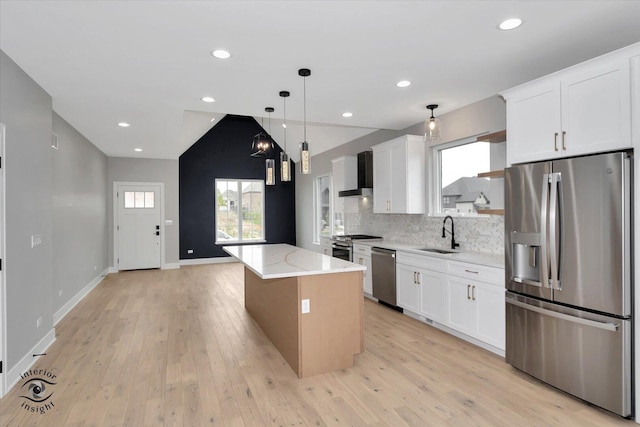 16451 Kayla Dr, Lemont, IL 60439 - kitchen featuring stainless steel appliances, wall chimney exhaust hood, a kitchen island, decorative backsplash, and light wood finished floors