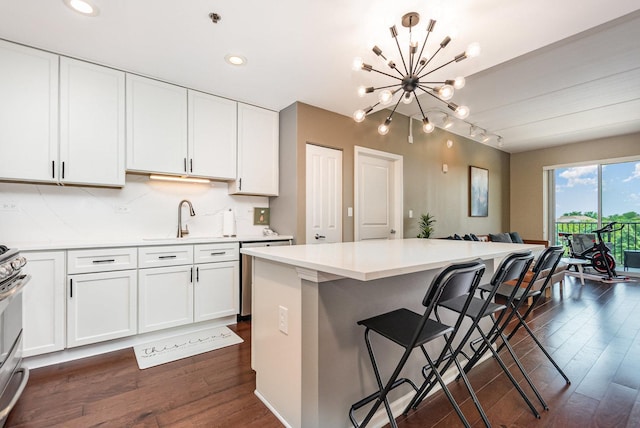 1199 E Port Clinton Rd Unit 305, Vernon Hills, IL 60061 - kitchen featuring dark wood finished floors, appliances with stainless steel finishes, a kitchen bar, light countertops, and recessed lighting
