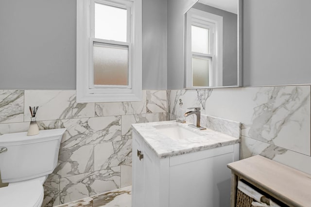 5424 N Lotus Ave, Chicago, IL 60630 - half bathroom with tile walls, vanity, plenty of natural light, marble finish flooring, and a wainscoted wall