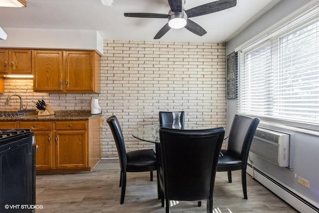 6530 W 94th Pl Unit 2A, Oak Lawn, IL 60453 - dining room featuring baseboard heating, ceiling fan, brick wall, and light wood-style floors