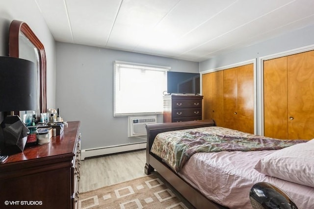 6530 W 94th Pl Unit 2A, Oak Lawn, IL 60453 - bedroom featuring a baseboard radiator, light wood-style floors, a wall mounted air conditioner, and two closets
