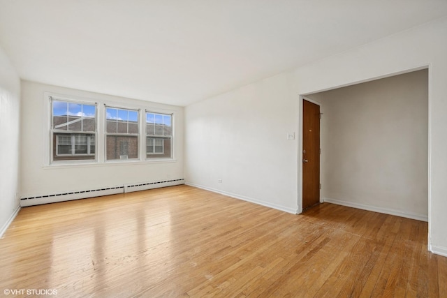 2424 W Farragut Ave Unit 3B, Chicago, IL 60625 - empty room with a baseboard radiator and wood finished floors