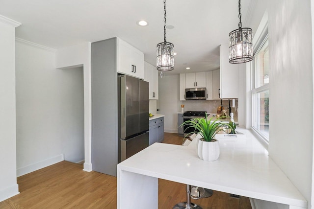 7248 N Kildare Ave, Lincolnwood, IL 60712 - kitchen with stainless steel appliances, a chandelier, recessed lighting, a peninsula, and white cabinets