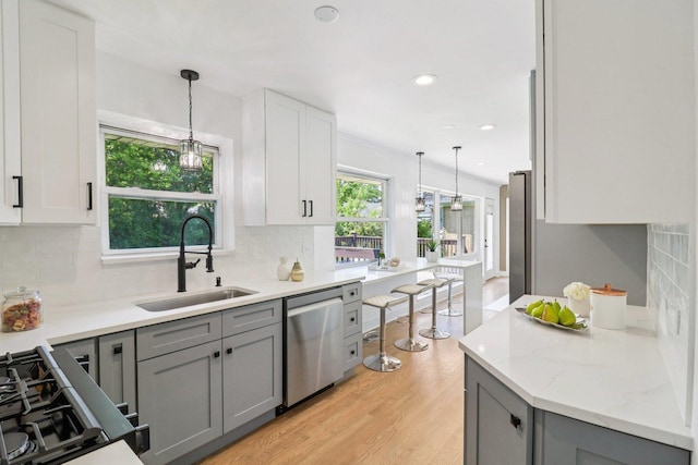 7248 N Kildare Ave, Lincolnwood, IL 60712 - kitchen with dishwasher, gray cabinets, decorative backsplash, pendant lighting, and light wood-style flooring