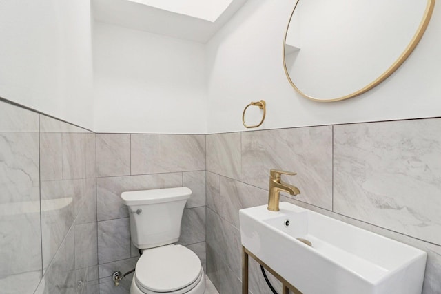 7248 N Kildare Ave, Lincolnwood, IL 60712 - bathroom with tile walls, vanity, a skylight, and wainscoting