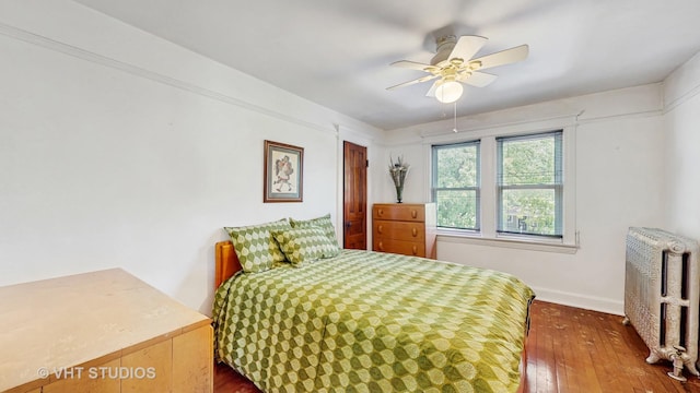 1320 Oak Park Ave, Berwyn, IL 60402 - bedroom with radiator heating unit, dark wood-style flooring, and ceiling fan