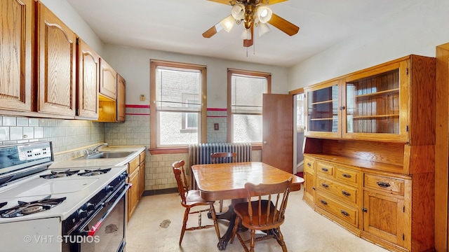 1320 Oak Park Ave, Berwyn, IL 60402 - kitchen with white range, a ceiling fan, light countertops, wainscoting, and radiator