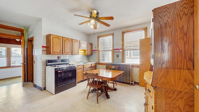 1320 Oak Park Ave, Berwyn, IL 60402 - kitchen featuring white gas range, radiator, a ceiling fan, tasteful backsplash, and light countertops
