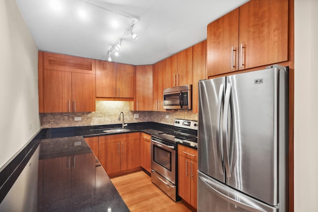 3033 N Sheridan Rd Unit 603, Chicago, IL 60657 - kitchen featuring stainless steel appliances, brown cabinets, tasteful backsplash, light wood-type flooring, and rail lighting