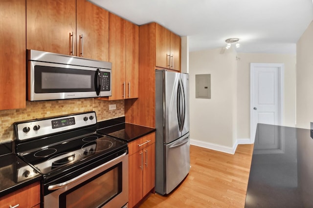 3033 N Sheridan Rd Unit 603, Chicago, IL 60657 - kitchen with stainless steel appliances, electric panel, backsplash, light wood-style floors, and brown cabinetry