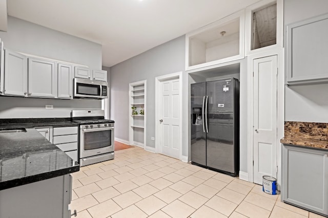 2713 W 24th Pl, Chicago, IL 60608 - kitchen featuring stainless steel appliances, dark stone countertops, and light tile patterned flooring