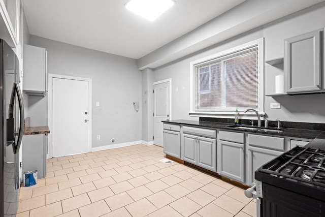 2713 W 24th Pl, Chicago, IL 60608 - kitchen with stainless steel fridge, black gas range, and gray cabinets
