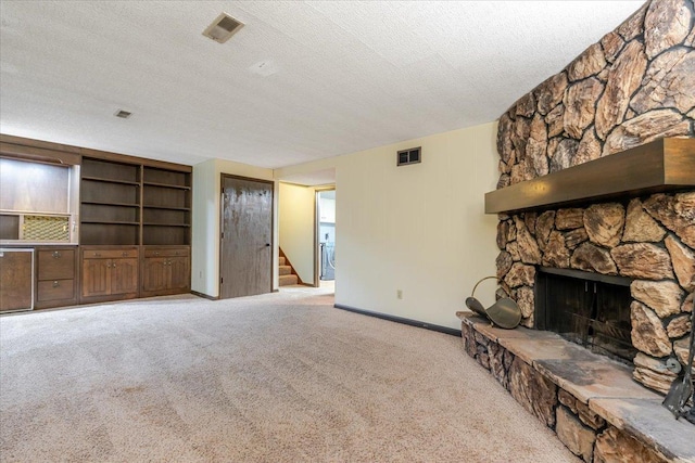 106 Sandra Ln, Normal, IL 61761 - unfurnished living room featuring stairs, a textured ceiling, carpet floors, and a stone fireplace