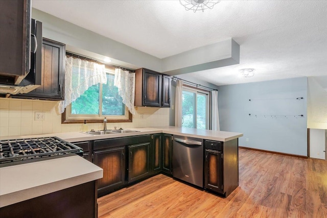 106 Sandra Ln, Normal, IL 61761 - kitchen featuring appliances with stainless steel finishes, a peninsula, light countertops, decorative backsplash, and light wood-style floors