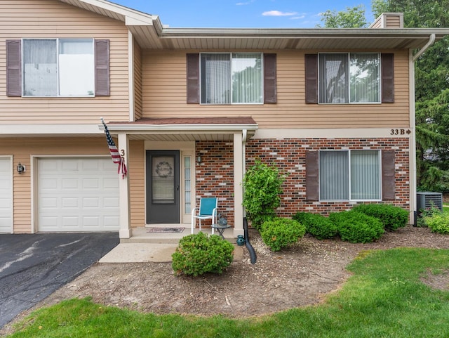 33 E Hickory St Unit A, Lombard, IL 60148 - townhome / multi-family property featuring brick siding, a chimney, driveway, and a garage