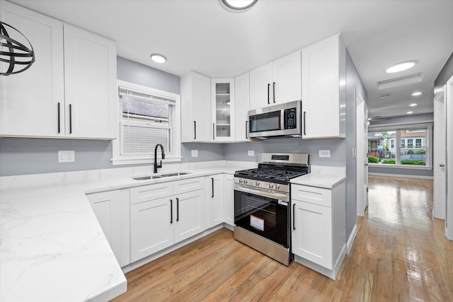 7133 S Honore St, Chicago, IL 60636 - kitchen with stainless steel appliances, light wood finished floors, light stone counters, white cabinets, and recessed lighting