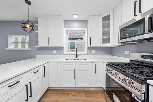 7133 S Honore St, Chicago, IL 60636 - kitchen featuring appliances with stainless steel finishes, white cabinetry, and light stone counters