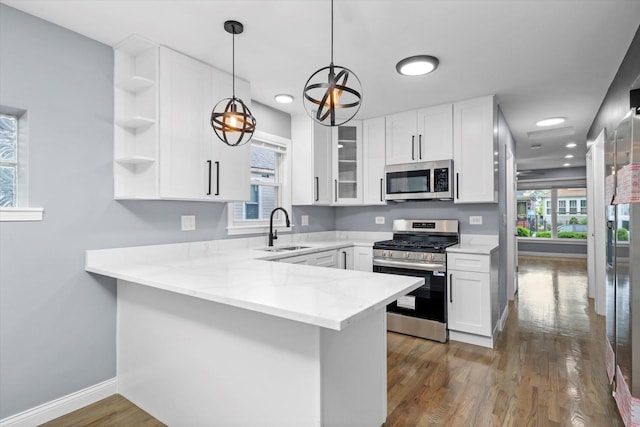 7133 S Honore St, Chicago, IL 60636 - kitchen with appliances with stainless steel finishes, a peninsula, healthy amount of natural light, white cabinets, and recessed lighting