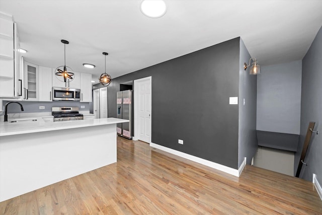 7133 S Honore St, Chicago, IL 60636 - kitchen with appliances with stainless steel finishes, white cabinetry, light wood-type flooring, light countertops, and glass insert cabinets