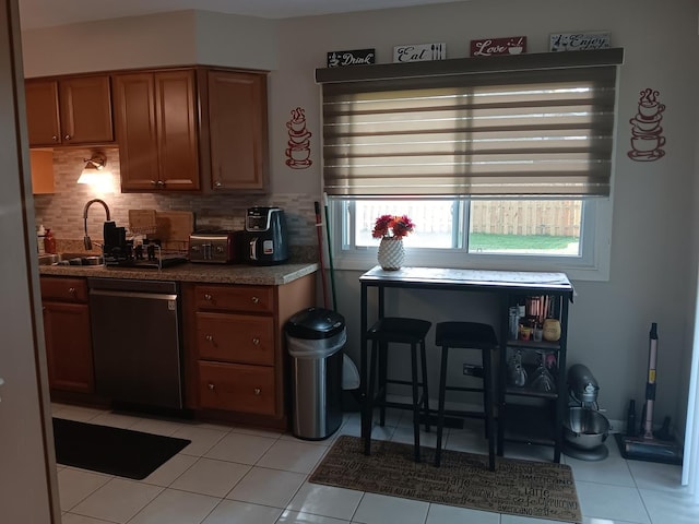 853 Greenbriar Ln, University Park, IL 60484 - kitchen featuring dishwasher, brown cabinets, decorative backsplash, light tile patterned floors, and dark countertops