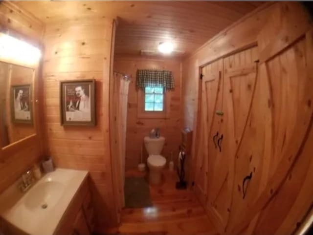 11 Cedar Ln, Putnam, IL 61560 - bathroom featuring wooden ceiling, vanity, wood finished floors, wooden walls, and a shower with curtain