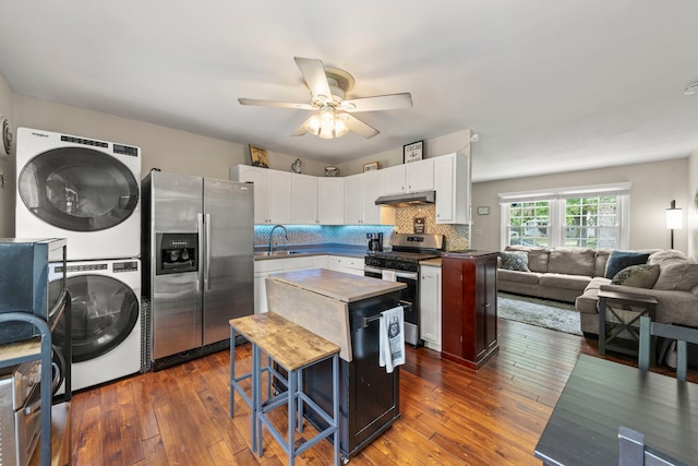 19 Briar Ln, Geneva, IL 60134 - kitchen featuring appliances with stainless steel finishes, stacked washer / dryer, white cabinetry, a ceiling fan, and under cabinet range hood