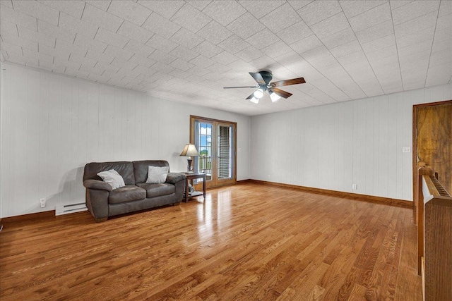 708 N 1950th Rd, Tonica, IL 61370 - living area with wood finished floors, a ceiling fan, a baseboard radiator, and wooden walls