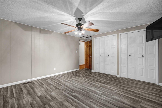 708 N 1950th Rd, Tonica, IL 61370 - unfurnished bedroom with wood finished floors, two closets, a textured ceiling, and ceiling fan