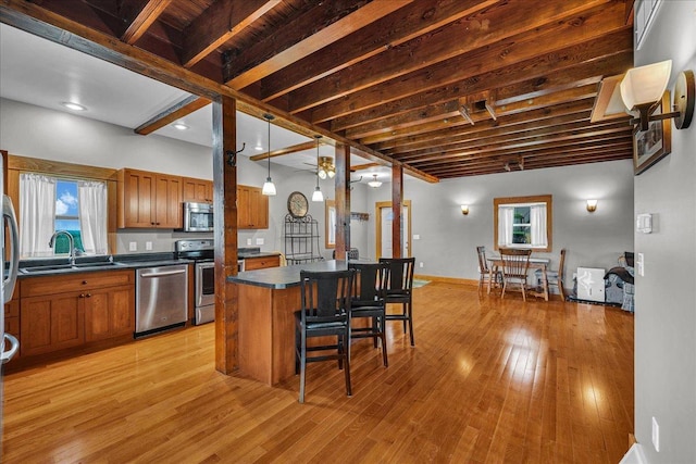 708 N 1950th Rd, Tonica, IL 61370 - kitchen featuring stainless steel appliances, brown cabinets, dark countertops, a breakfast bar area, and light wood-style floors