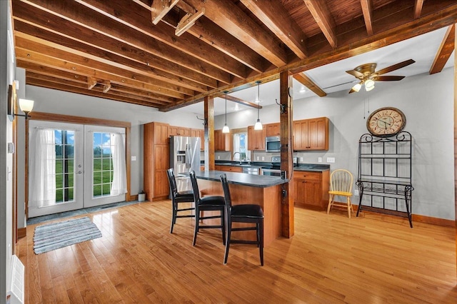 708 N 1950th Rd, Tonica, IL 61370 - kitchen with stainless steel appliances, dark countertops, brown cabinets, a kitchen bar, and french doors
