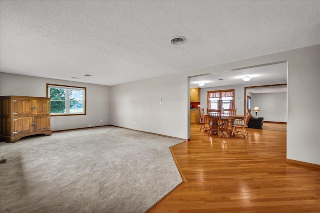 708 N 1950th Rd, Tonica, IL 61370 - unfurnished living room with light wood-style flooring, plenty of natural light, and a textured ceiling