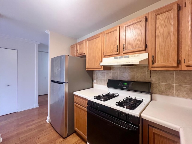 3001 S Michigan Ave Unit 909, Chicago, IL 60616 - kitchen with gas range, under cabinet range hood, freestanding refrigerator, light countertops, and light wood-style flooring