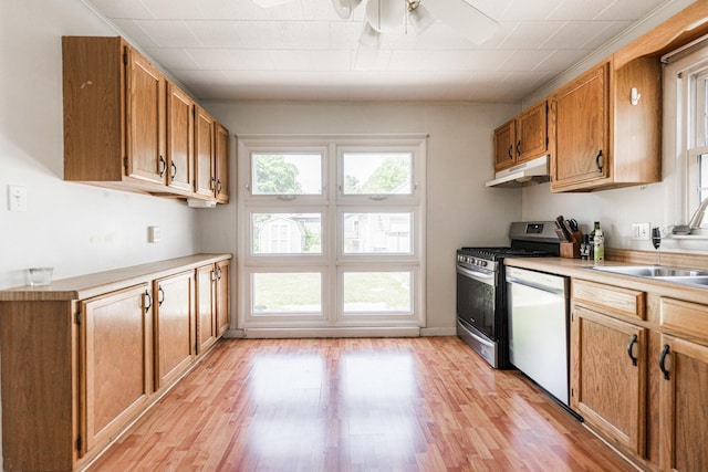 1020 N 8th St, Rochelle, IL 61068 - kitchen with white dishwasher, under cabinet range hood, stainless steel gas range oven, ceiling fan, and light wood-style floors
