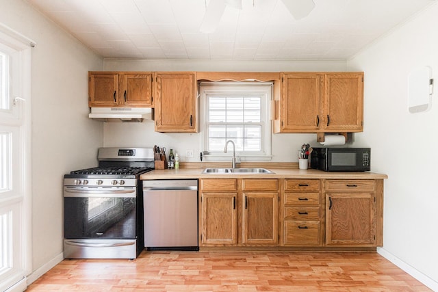 1020 N 8th St, Rochelle, IL 61068 - kitchen with appliances with stainless steel finishes, under cabinet range hood, light wood-type flooring, light countertops, and crown molding