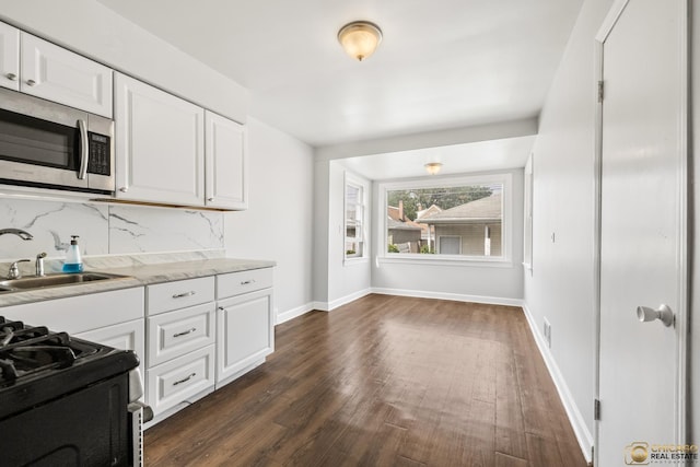 7220 S Spaulding Ave, Chicago, IL 60629 - kitchen with stainless steel microwave, dark wood-type flooring, white cabinetry, backsplash, and light countertops