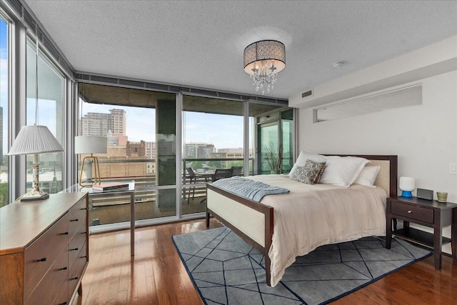 800 Elgin Rd Unit 1021, Evanston, IL 60201 - bedroom with wood finished floors, multiple windows, a wall of windows, a chandelier, and a textured ceiling