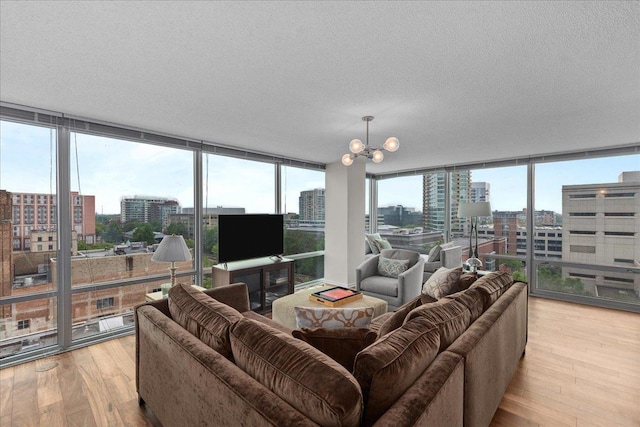 800 Elgin Rd Unit 1021, Evanston, IL 60201 - living area featuring a wall of windows, light wood-type flooring, a chandelier, and a textured ceiling