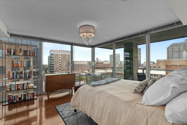 800 Elgin Rd Unit 1021, Evanston, IL 60201 - bedroom with a view of city, wood finished floors, expansive windows, a textured ceiling, and a chandelier