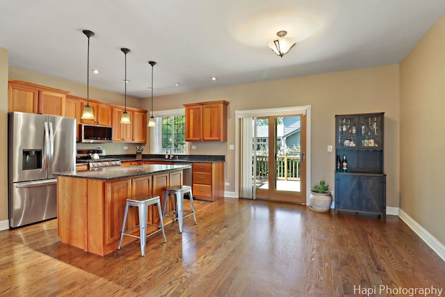 1340 Park Ave, Winthrop Harbor, IL 60096 - kitchen featuring appliances with stainless steel finishes, a kitchen island, dark wood-style flooring, a breakfast bar, and recessed lighting