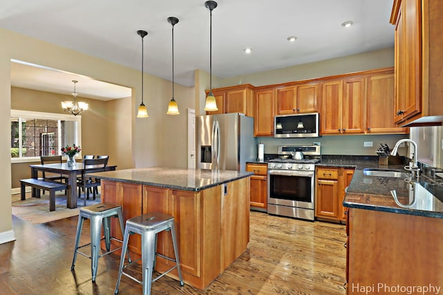 1340 Park Ave, Winthrop Harbor, IL 60096 - kitchen with appliances with stainless steel finishes, light wood finished floors, brown cabinetry, a kitchen bar, and recessed lighting