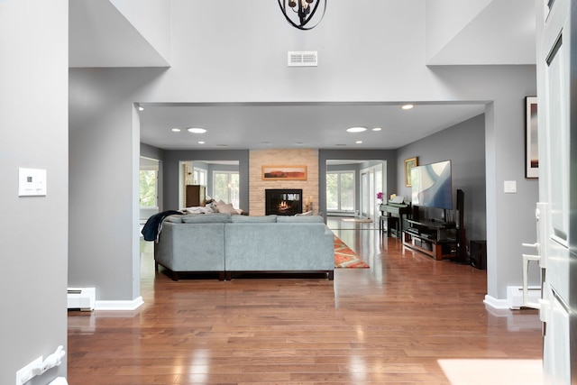 1060 Highland Ave, Lake Forest, IL 60045 - living area featuring a baseboard heating unit, wood finished floors, a large fireplace, and recessed lighting