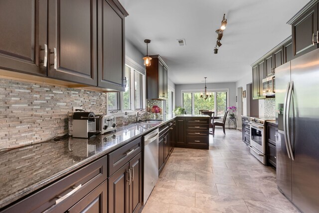 1060 Highland Ave, Lake Forest, IL 60045 - kitchen with appliances with stainless steel finishes, tasteful backsplash, dark stone countertops, and a chandelier