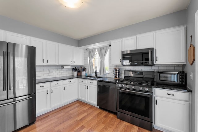 1361 Amherst Ct, Grayslake, IL 60030 - kitchen with appliances with stainless steel finishes, light wood-style flooring, tasteful backsplash, and white cabinetry