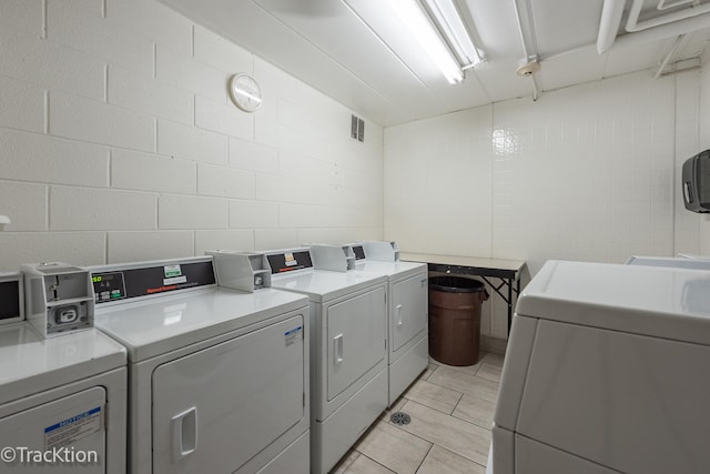 1056 N Mill St Unit 305, Naperville, IL 60563 - shared laundry room featuring washing machine and dryer, concrete block wall, and light tile patterned floors