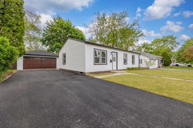 519 Everette Ave, Romeoville, IL 60446 - view of front of house with a detached garage, an outbuilding, and a front lawn