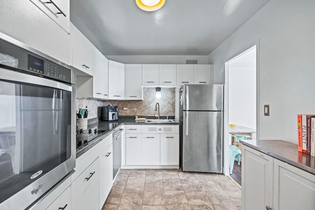 6301 N Sheridan Rd Unit 7N, Chicago, IL 60660 - kitchen featuring appliances with stainless steel finishes, dark countertops, decorative backsplash, and white cabinets