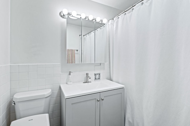 6301 N Sheridan Rd Unit 7N, Chicago, IL 60660 - bathroom featuring vanity, wainscoting, tile walls, and curtained shower
