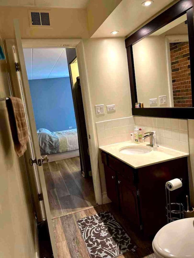 900 S River Rd Unit 3A, Des Plaines, IL 60016 - ensuite bathroom featuring vanity, wood finished floors, and decorative backsplash