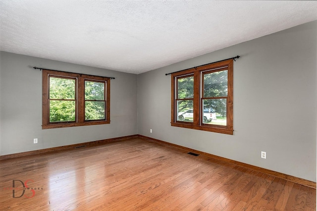 305 W 3rd St, Streator, IL 61364 - unfurnished room with healthy amount of natural light, light wood-style floors, and a textured ceiling